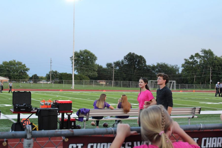 Senior cross country runner Jacob Blassingame being escorted by junior Ella Smith.