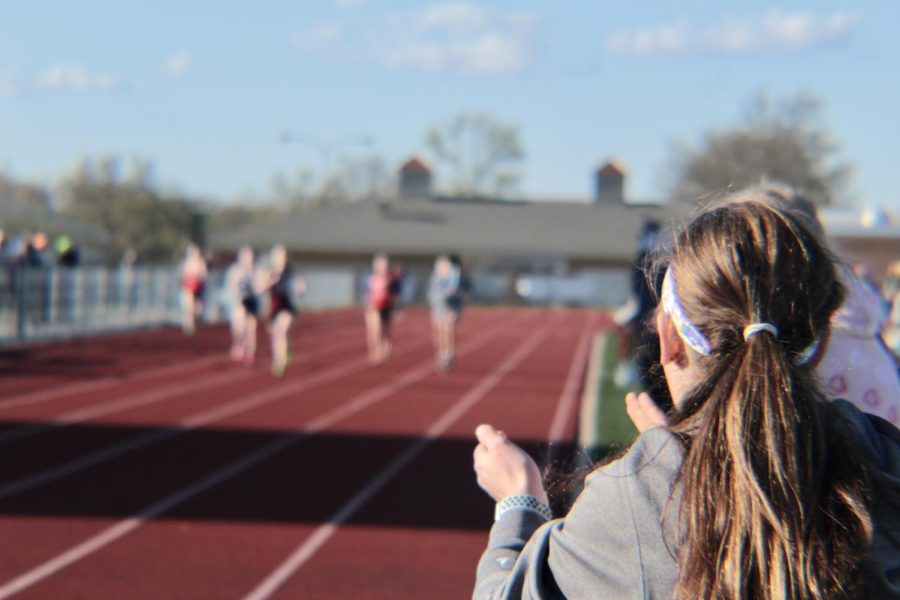 Sophomore Vivian Jones clapping for members of the 4x400.