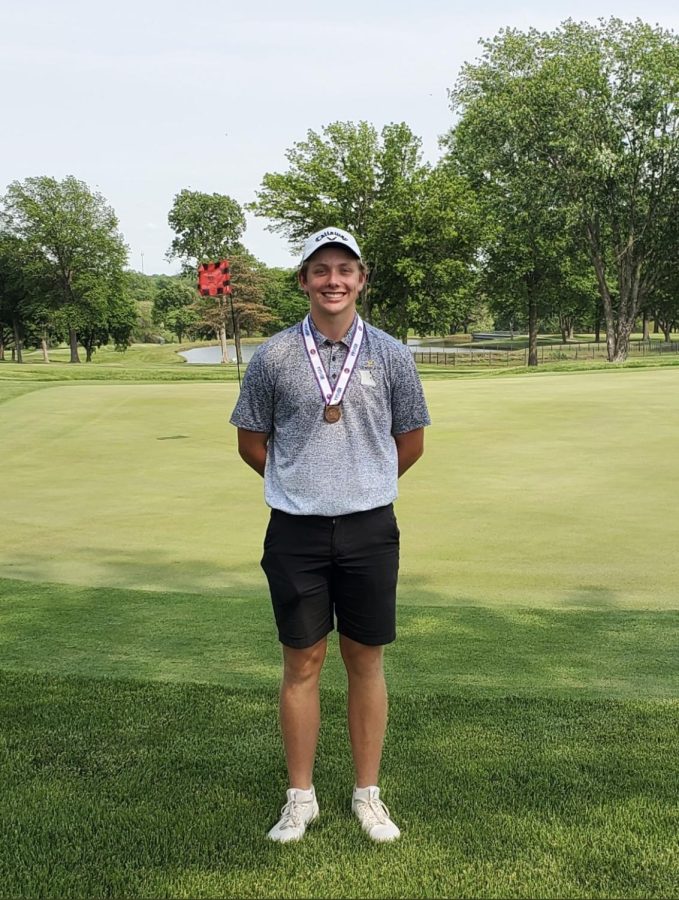 Junior Ian Hollander at the MSHSAA state golf tournament with a medal.